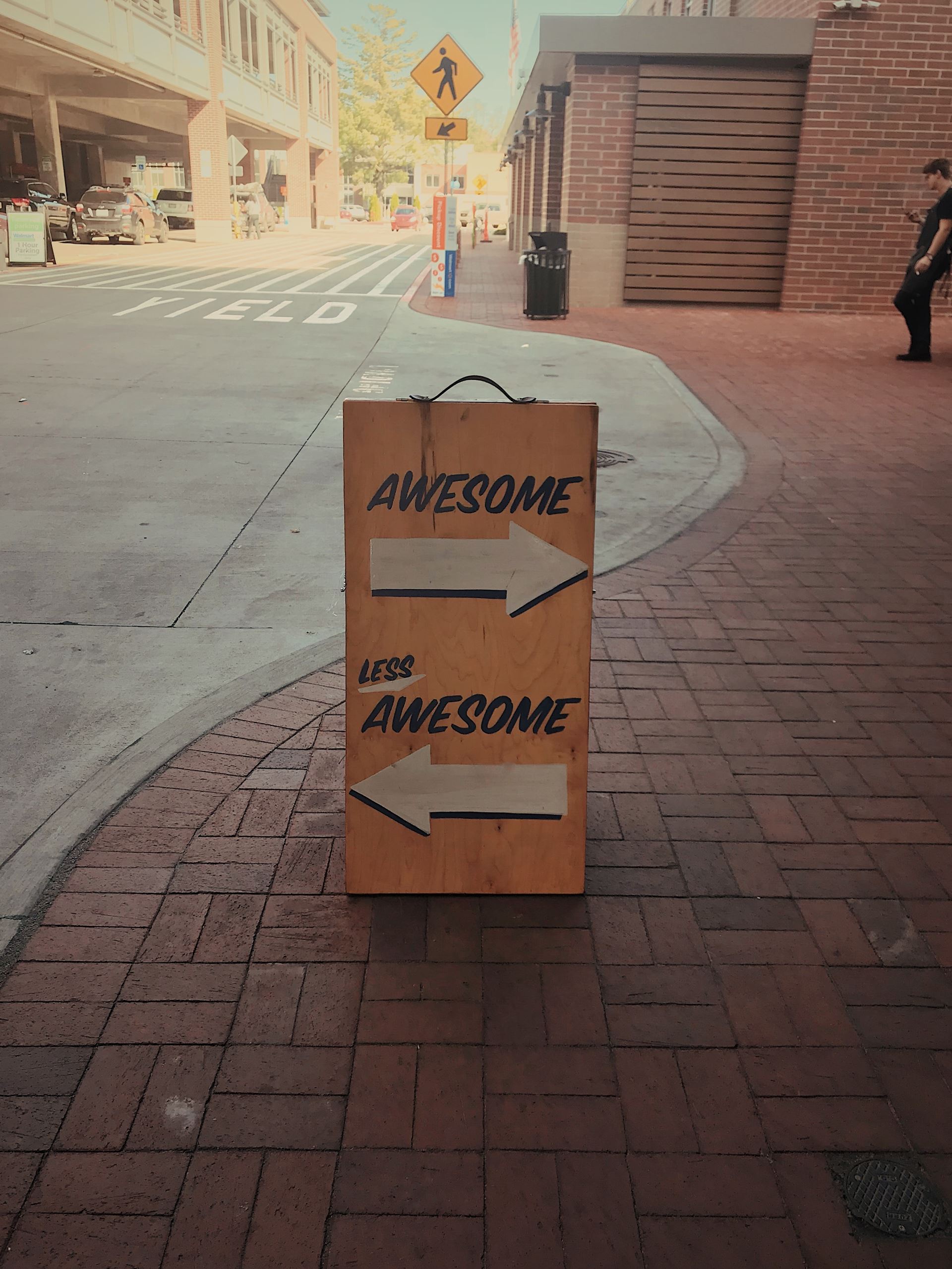 street sign post with arrows saying awesome or less awesome